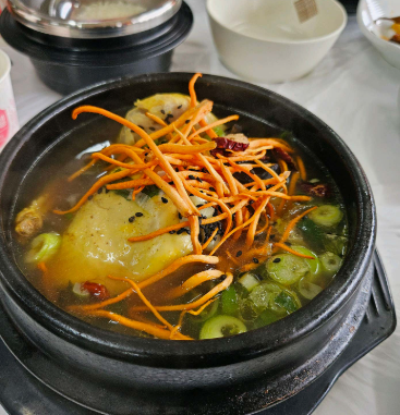 닭 위에 주황빛 동충하초를 얹은 삼계탕